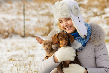 Woman playing with dogs during winter