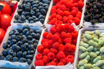 Delicious juicy colorful berries for sale at the market. Raspberry, mulberry, red currant, blueberry and others