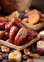 Various dried fruits and nuts in wooden dish.