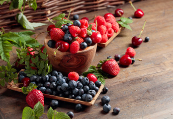 Berries closeup colorful assorted mix of strawberry, blueberry, raspberry and sweet cherry on a old...