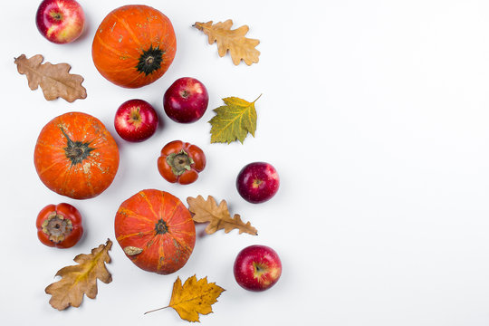 Autumn composition. Fall, autumn, halloween concept. Pumpkins, apples, persimmons and dried autumn leaves on white background. Flat lay, top view, copy space
