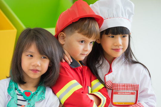 Three kid dress up to fireman and doctor and chef at roll play classroom,Kindergarten preschool education concept