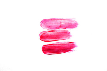 Smudged pink liquid lipstick, liquid blush isolated on white background. Concept of make up and beauty.