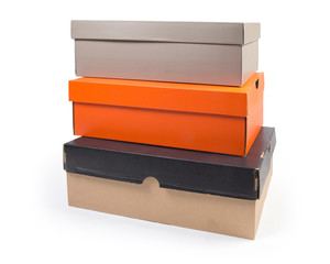Stack of different closed cardboard shoe boxes on white background