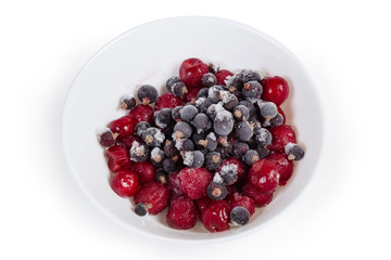 Various frozen berries in bowl on a white background