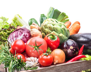 Fresh multi-colored vegetables in wooden crate.
