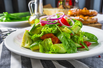The salad with an avocado and tomatoes on a striped napkin