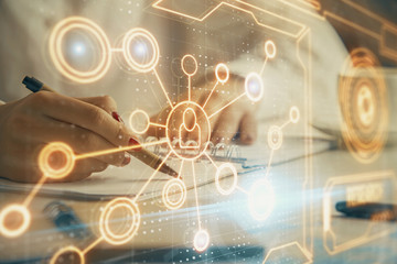 Social network theme hologram over hands taking notes background. Concept of global international...