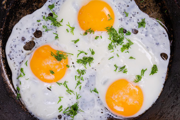 Top view of three fried eggs in the frying pan