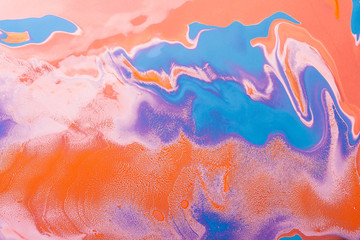 Acrylic Fluid Art. Blue purple curls on orange waves. Abstract modern background or texture