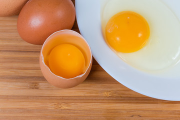 Broken eggs in open shell and on dish, top view