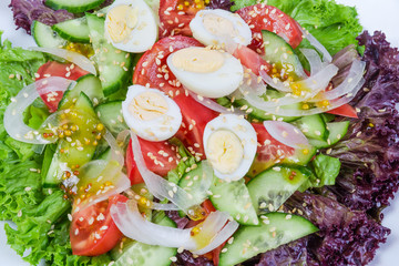 Background of vegetable salad with boiled quail eggs close-up