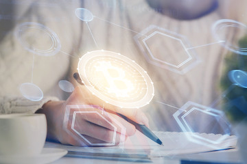 Cryptocurrency hologram over hands taking notes background. Concept of blockchain. Multi exposure