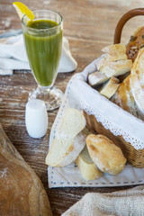 Homemade fresh baked bread slices and green detox drink on the wooden table	