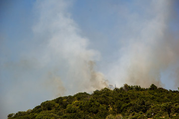 Fototapeta premium Forest Fire Smoke On The Slopes Hills. Fire In Mountain Forest. Wild Fire In Forests