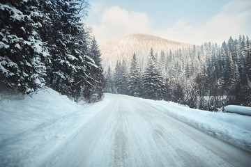 Obraz premium road in winter forest with mountain ahead