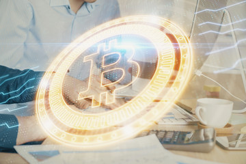 Crypto currency theme hologram with businessman working on computer on background. Concept of blockchain. Multi exposure.