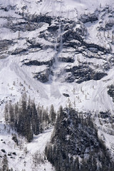 Avalanche on steep snow apline hillside