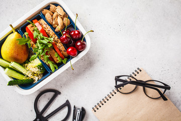 Back to school concept.  Lunch box with sandwich, fruit, snacks, notebook, pencils and school...