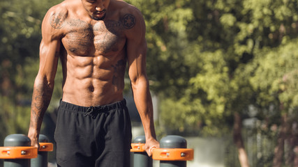 Muscular Shirtless Man Doing Push Ups On Parallel Bars