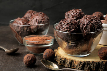 Chocolate ice cream with liquid chocolate with almonds and coffee beans on a dark background.