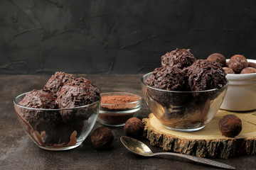 Chocolate ice cream with liquid chocolate with almonds and coffee beans on a dark background.