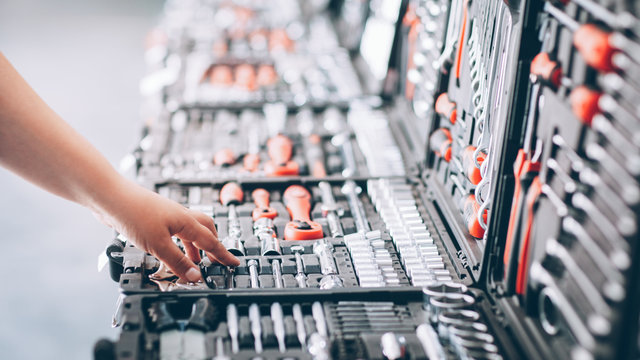 Tool store showcase. Cropped shot of worker choosing instruments for auto repair.