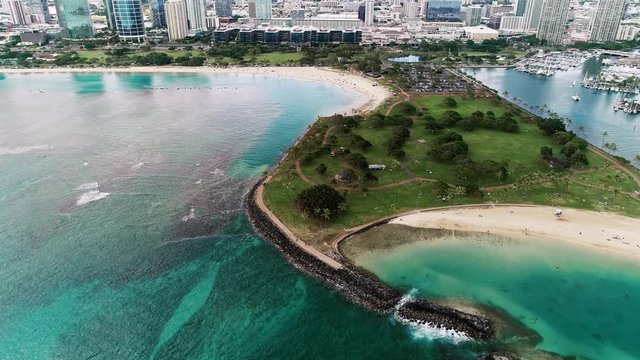 Flying high over Magic Island Lagoon and Ala Moana Beach, with the city in the background.