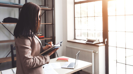 Time management, planning, scheduling concept. Successful business woman standing, taking notes in...