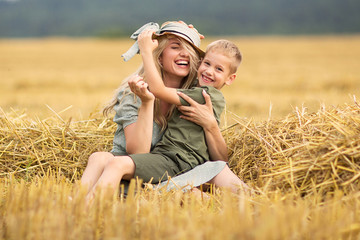 Naklejka na ściany i meble Family photo mom and son playing in the field. Family in the countryside. Family value