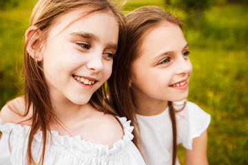 Obraz premium Dwie piękne siostry nastolatki w białych sukienkach w przyrodzie.