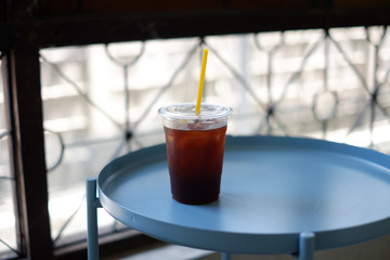 A plastic glass of cold brew coffee on blue table ,Selective focus.