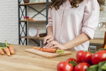 Brunette woman cutting carrots