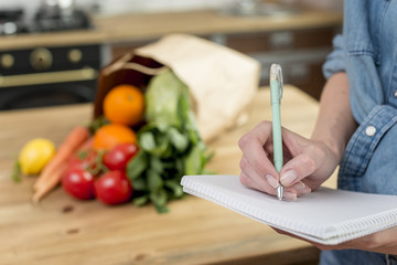 Person writing a recipe in the notebook