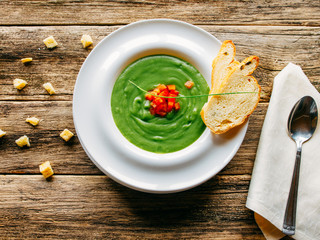 Vegetarian food. Vegetable soup puree served with toasted croutons on rustic wooden background.