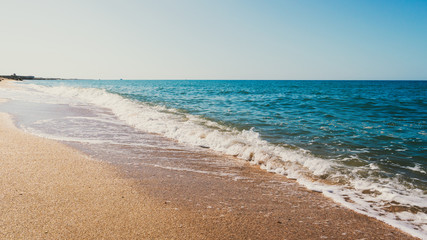 Empty summer beach with golden sand and azure water