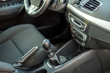 Fototapeta na wymiar Luxurious car black leather interior. Handbrake manual brake and gearshift stick on blurred background. Transportation, design, modern technology concept.