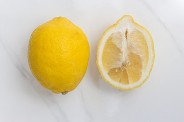 Lemons arranged on a white marble counter top background 