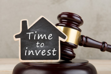 Real estate concept -auction gavel and little house with inscription Time to invest