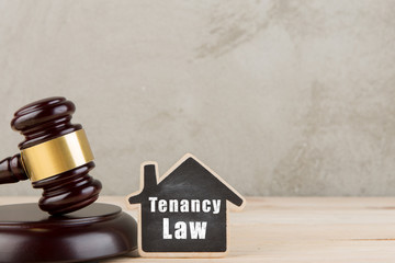 Real estate concept -auction gavel and little house with inscription Tenancy law
