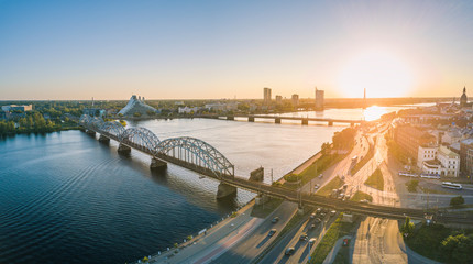 Panoramic view over Riga city at sunset. Iconic railroad bridge and old town panorama. Picturesque scenery of historical architecture. National library of Latvia. 