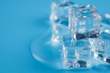 melting ice cubes on blue background