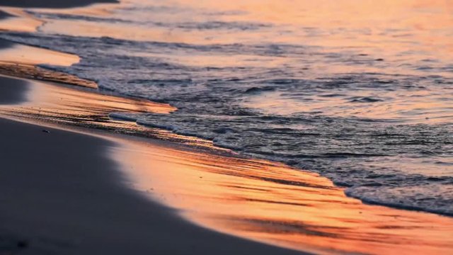 Real time shot of beach sunset with waves