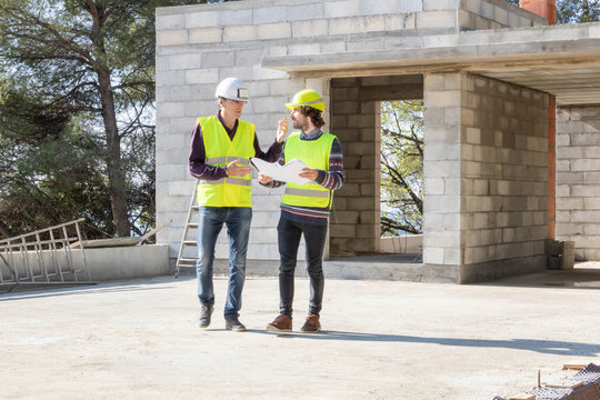 Visite de chantier, maison en construction : Architecte et contremaître en conversation