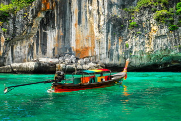 Fototapeta na wymiar Typical Thai boat at the entrance of Pileh lagoon, with, crystal clear waters, ko phi phi island, phuket, thailand