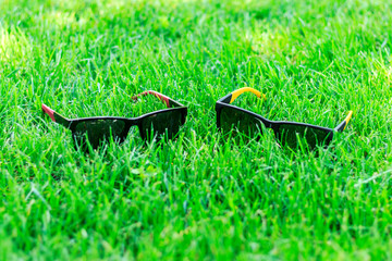 sun glasses on green grass on a sunny day