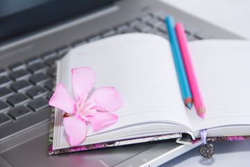 notebook for business, pink and blue pencils and laptop computer keys