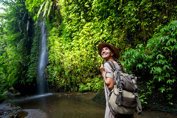 Naklejka premium Woman near waterfal on Bali, Indonesia&nbsp;
