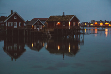Obraz premium Norway rorbu houses and mountains rocks over fjord landscape scandinavian travel view Lofoten islands. Night landscape.