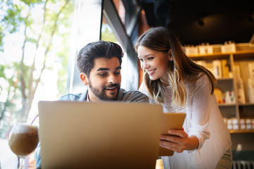Portrait of a cheerful couple shopping online with laptop